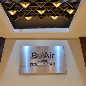 BelAir Unique A Wyndham Hotel Schild mit einer geometrischen Leuchte darüber.