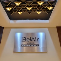 Señal de BelAir Unique, A Wyndham Hotel, con un elemento decorativo luminoso geométrico encima.