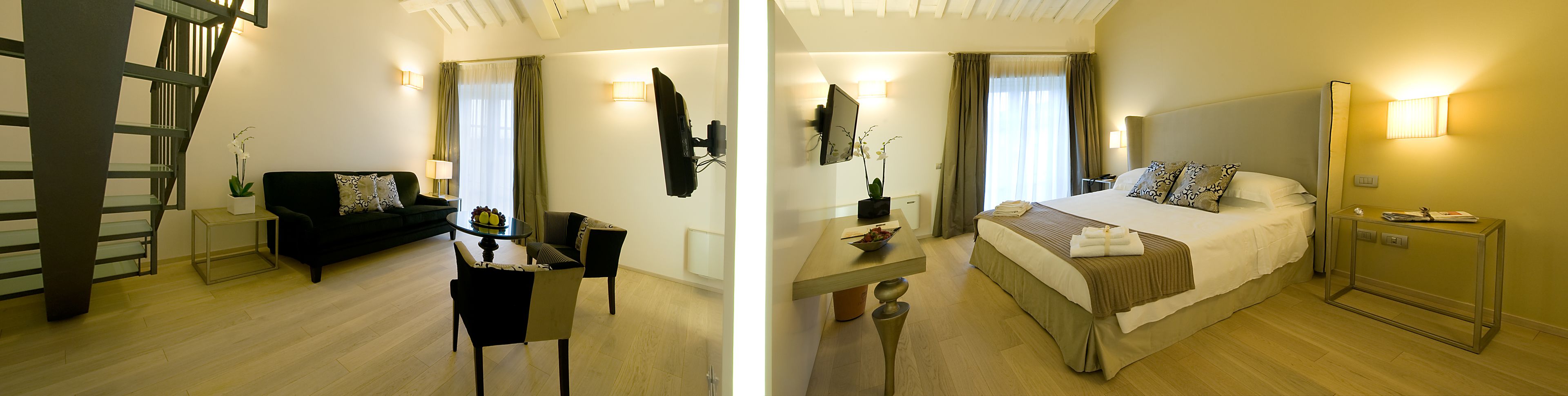 A hotel room with a bed, a desk, a chair, a table, and a mirror.
