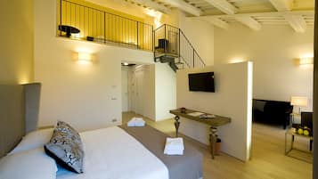 A hotel room with a bed, a desk, a TV, and a balcony.