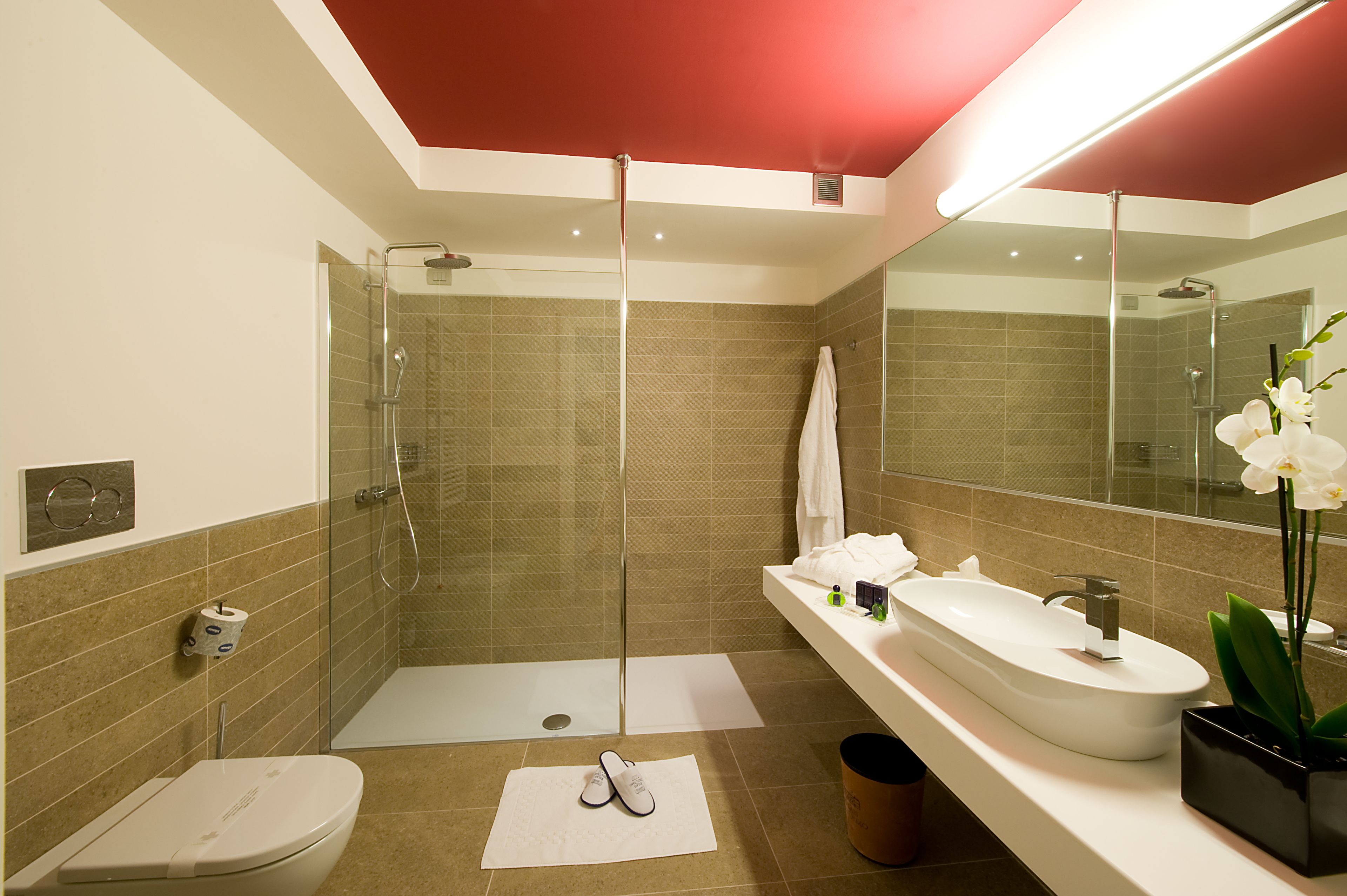 A modern bathroom with a glass shower enclosure, a white sink, and a large mirror.