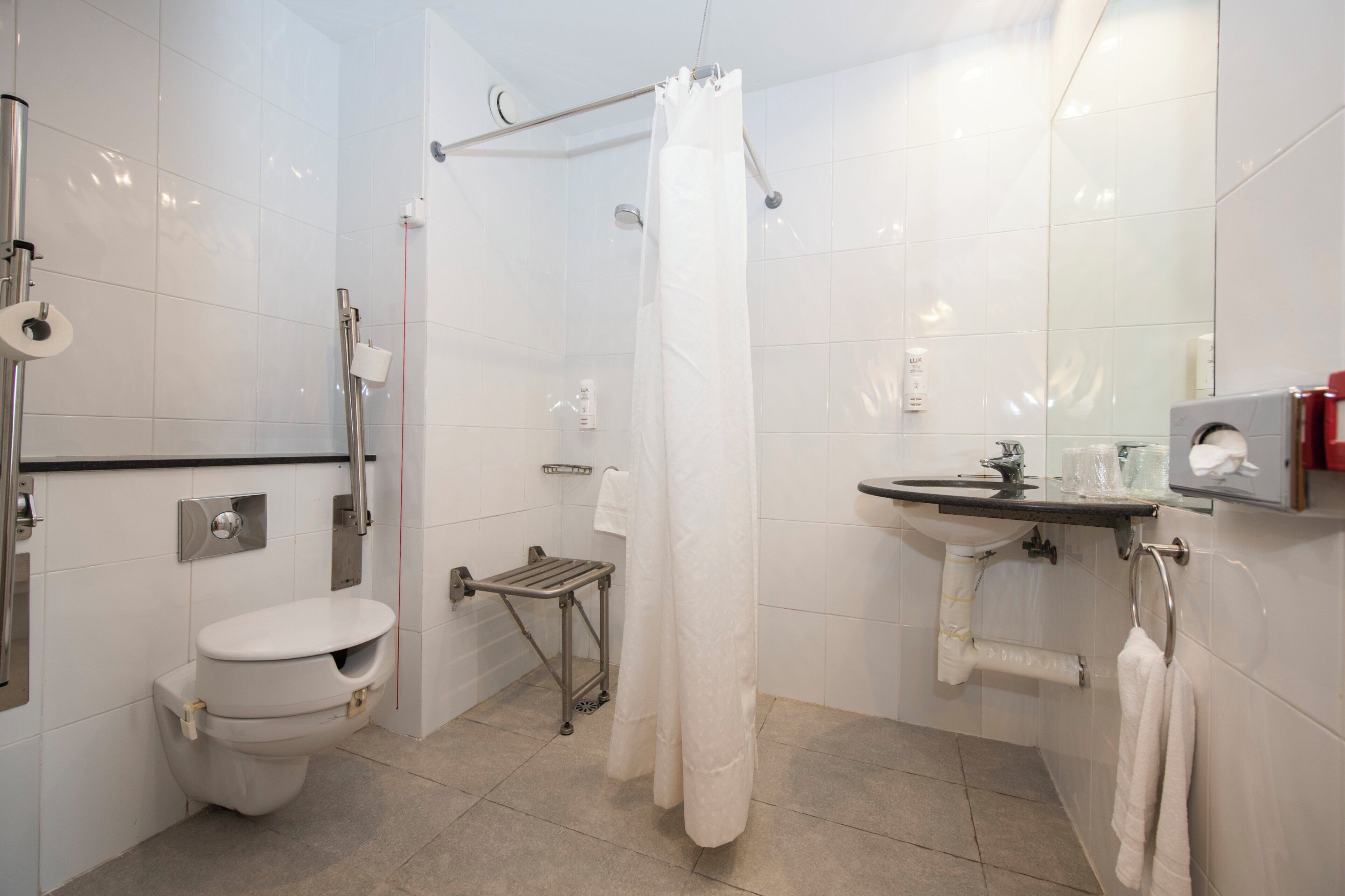 Une salle de bain moderne équipée de toilettes, d’une douche et d’un lavabo.