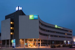 A Holiday Inn Express hotel with a modern design, featuring a prominent 'HH' sign on the roof and a large 'Holiday Inn Express' sign on the building. - Holiday Inn Express Barcelona - Molins de Rei by IHG (Molins de Rei)
