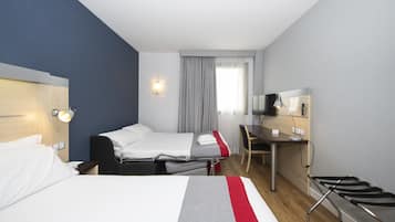 A hotel room with two beds, a desk, a chair, a TV, and a window with curtains.