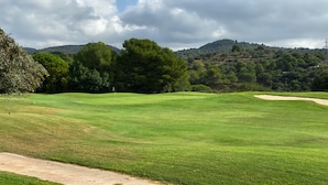 A golf course with a clear path, trees, and a hilly backdrop. - Holiday Inn Express Barcelona - Molins de Rei by IHG (Molins de Rei)