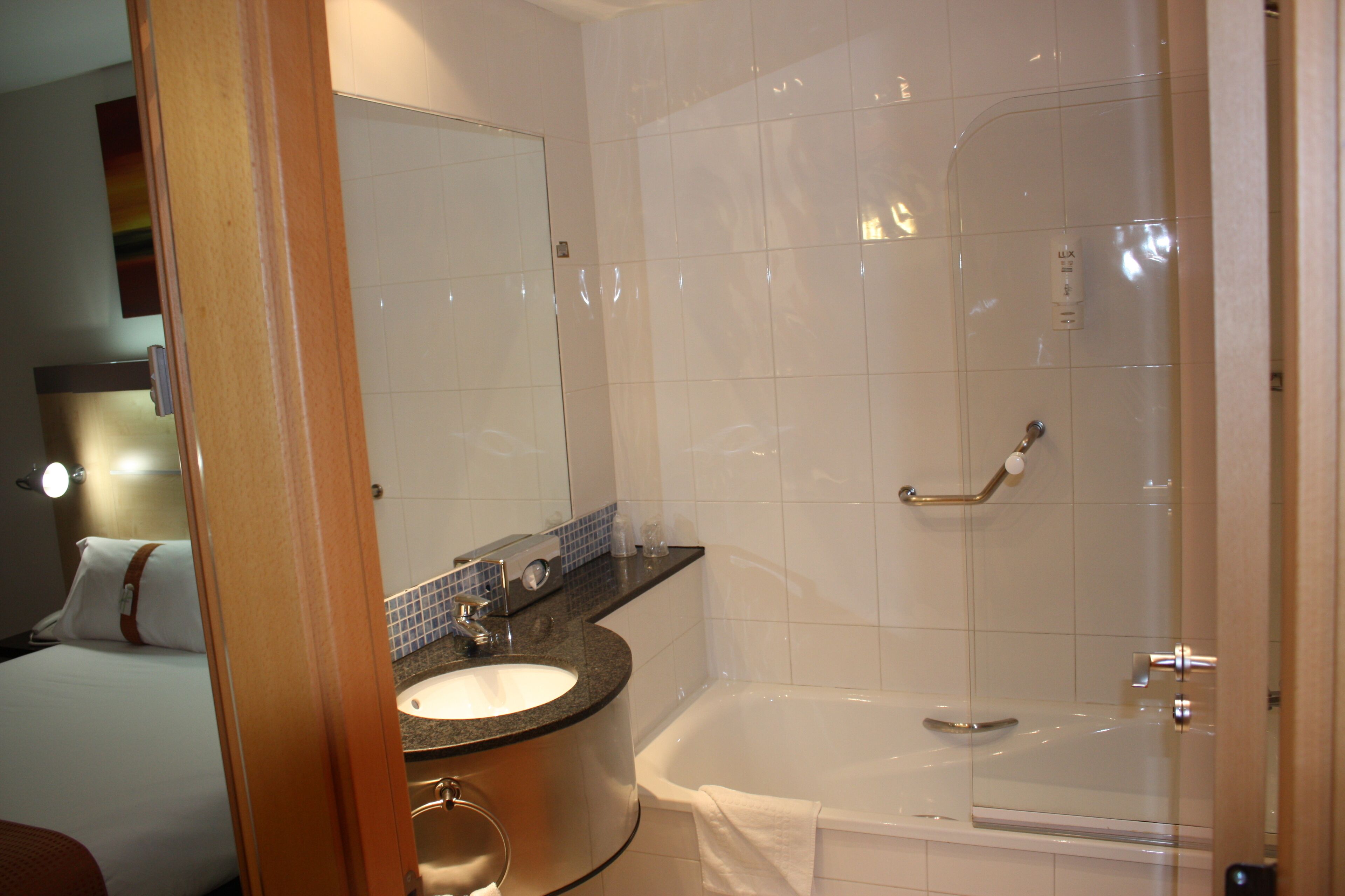 A modern bathroom with a bathtub, a sink, and a mirror.