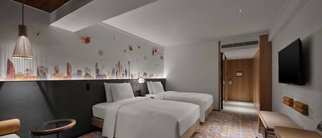 Una habitación de hotel moderna con una cama, mesitas de noche, una zona de estar y un televisor.
