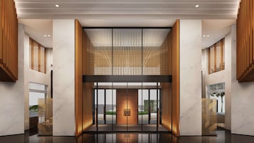 A modern hotel entrance with a central wooden door, vertical wooden slats, and a glass partition.