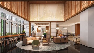 A spacious lobby with a high ceiling, modern furniture, and a central seating area.