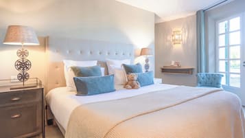 Quarto com uma cama grande, duas mesas de cabeceira, um criado-mudo, uma luminária na parede e uma janela com cortinas.