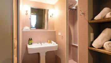 Ein Badezimmer mit Waschbecken, Spiegel und Dusche.