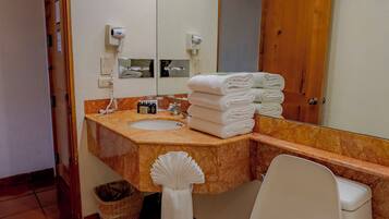 A bathroom with a toilet, a sink, a mirror, and a towel rack.