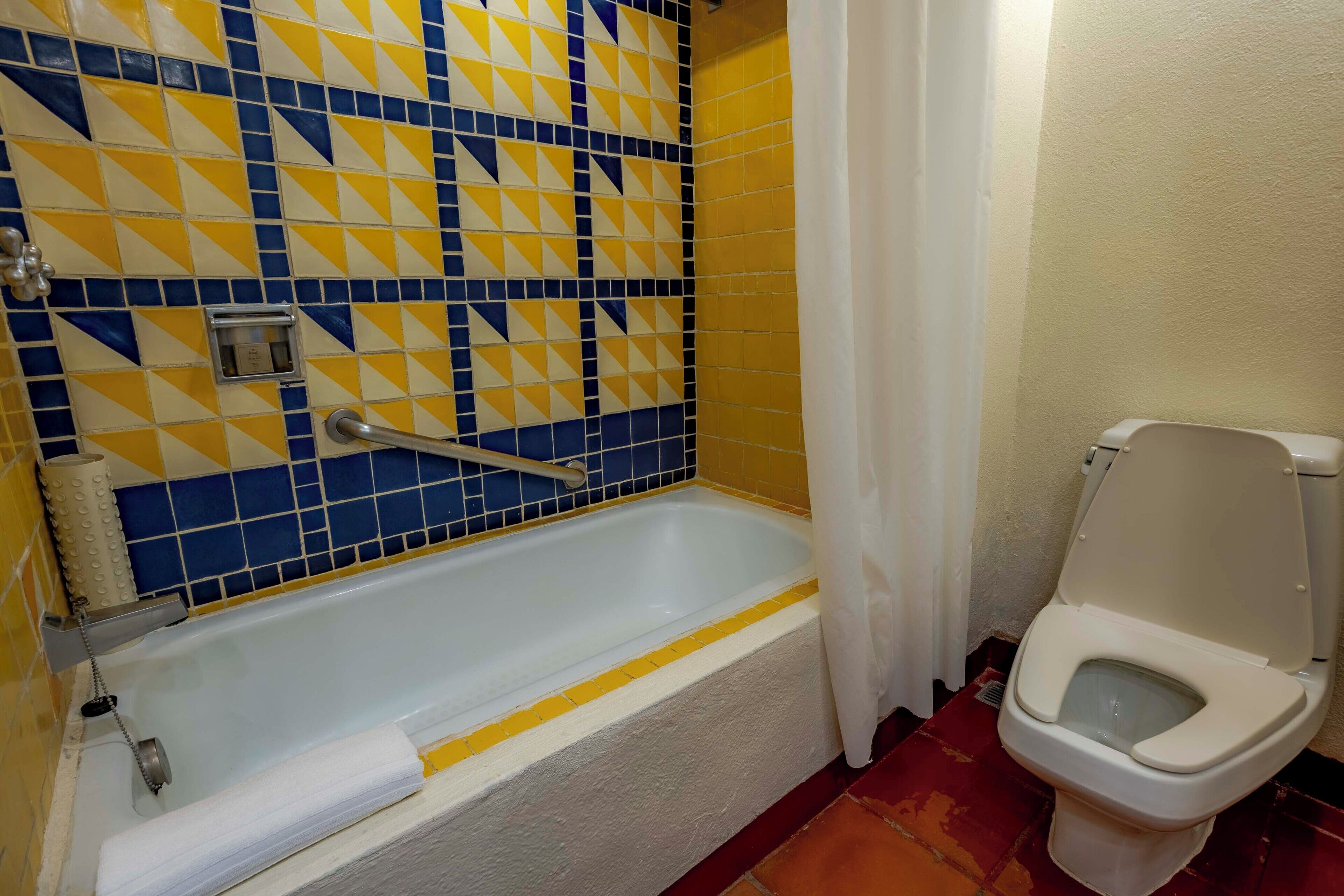 Ein Badezimmer mit Badewanne, Toilette und Duschvorhang.