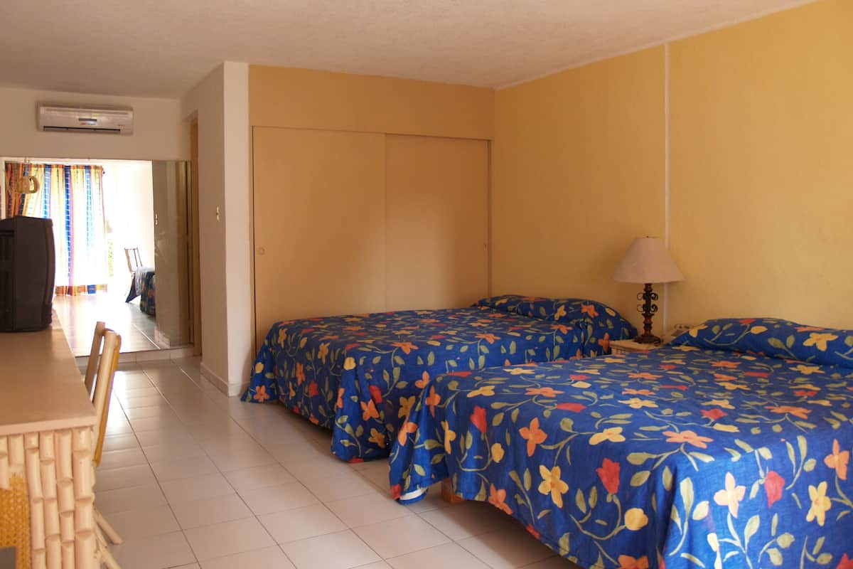 A hotel room with two beds, a desk, and a chair.
