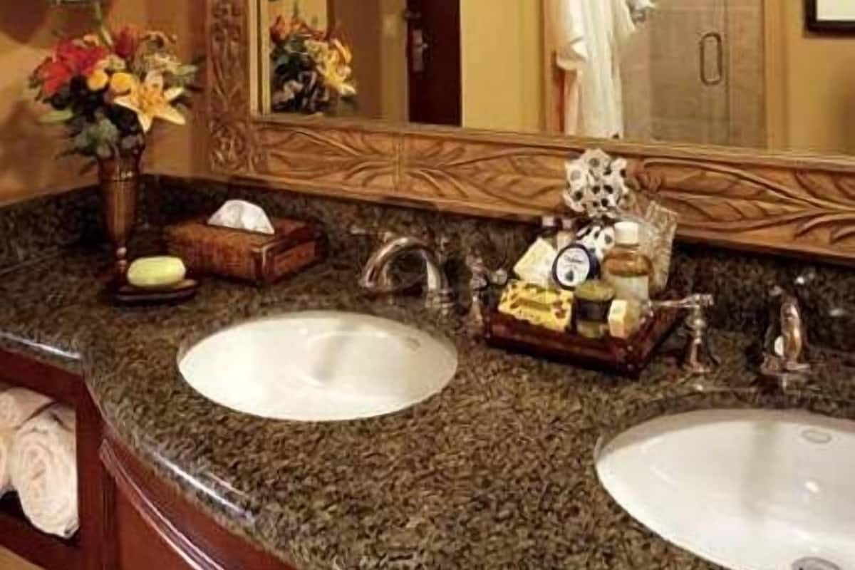 Un baño con dos lavamanos, un espejo y tocador.