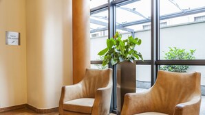 A room with two leather armchairs, a potted plant, and a sign reading "SALA COLAZIONI". - Hotel Des Etrangers (Milan)