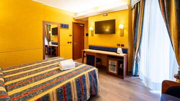 A hotel room with a large bed, a desk, and a television.