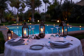 Una piscina al aire libre, sombrillas, sillones reclinables de piscina