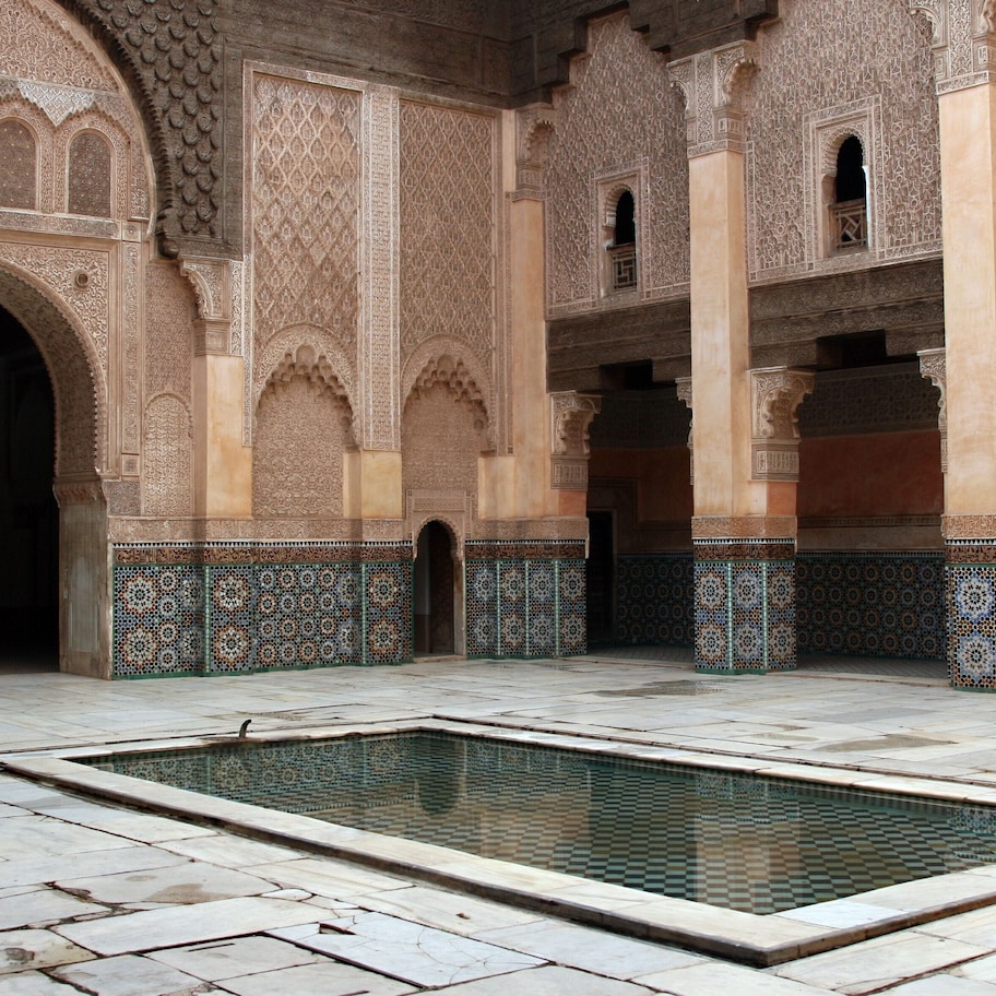 An interior courtyard with a pool, ornate arches, and patterned tile work.