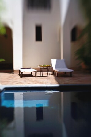 Alberca al aire libre, sombrillas en la alberca y camastros 