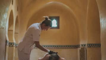 A staff member tends to a table in a room with a vaulted ceiling and a small window.