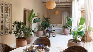 Suite Romantique, 1 chambre, bain à remous, côté jardin | Coin séjour | Télévisions à écran plasma