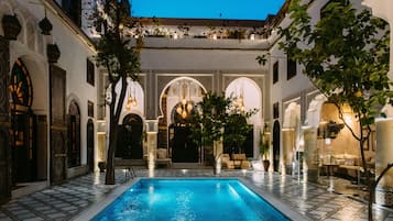 Una piscina al aire libre, tumbonas