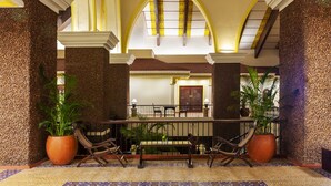 A lobby with a checkered floor, a central bench, and potted plants. - Caravela Beach Resort (Varca)