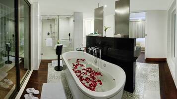 Une salle de bain moderne avec une baignoire sur pieds, une douche à parois de verre et un meuble-lavabo avec un miroir.