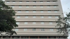 Un hôtel à plusieurs étages, doté d’une façade sobre, de nombreuses fenêtres et d’une enseigne indiquant qu’il s’agit d’un hôtel.