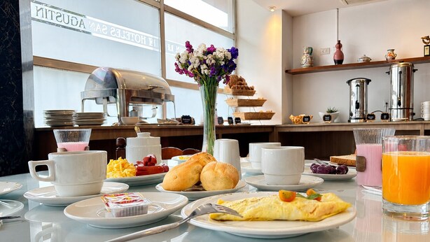 Un buffet de petit-déjeuner proposant une variété d’aliments, un coin café et un bar à jus.