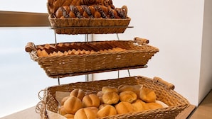 Une présentation de pains et de viennoiseries dans des paniers en osier.