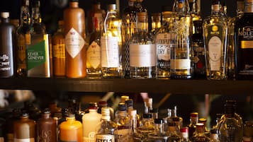 Forskellige flasker alkohol på hylder, blandt andet mærker som KEVER GENEVER og VORDING'S GIN.