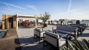 A rooftop terrace with outdoor seating and a covered area. - Hotel Urpi (Sabadell)