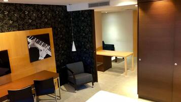 Una habitación de hotel moderna con una cama, un escritorio, una silla, un armario y una pared con estampado floral.