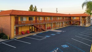 Un motel à la façade en briques, doté d’un parking couvert et composé d’un bâtiment à deux étages.