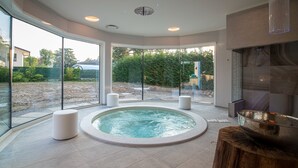 A modern spa area with a hot tub, large windows, and a view of the outdoors.