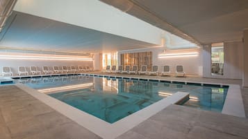 Una piscina techada, una piscina al aire libre de temporada, sombrillas