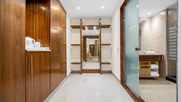 Een moderne badkamer met een douchecabine van glas, een houten wastafelmeubel en een betegelde vloer.