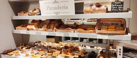 Una vitrina de panadería con panes, pasteles y postres variados.