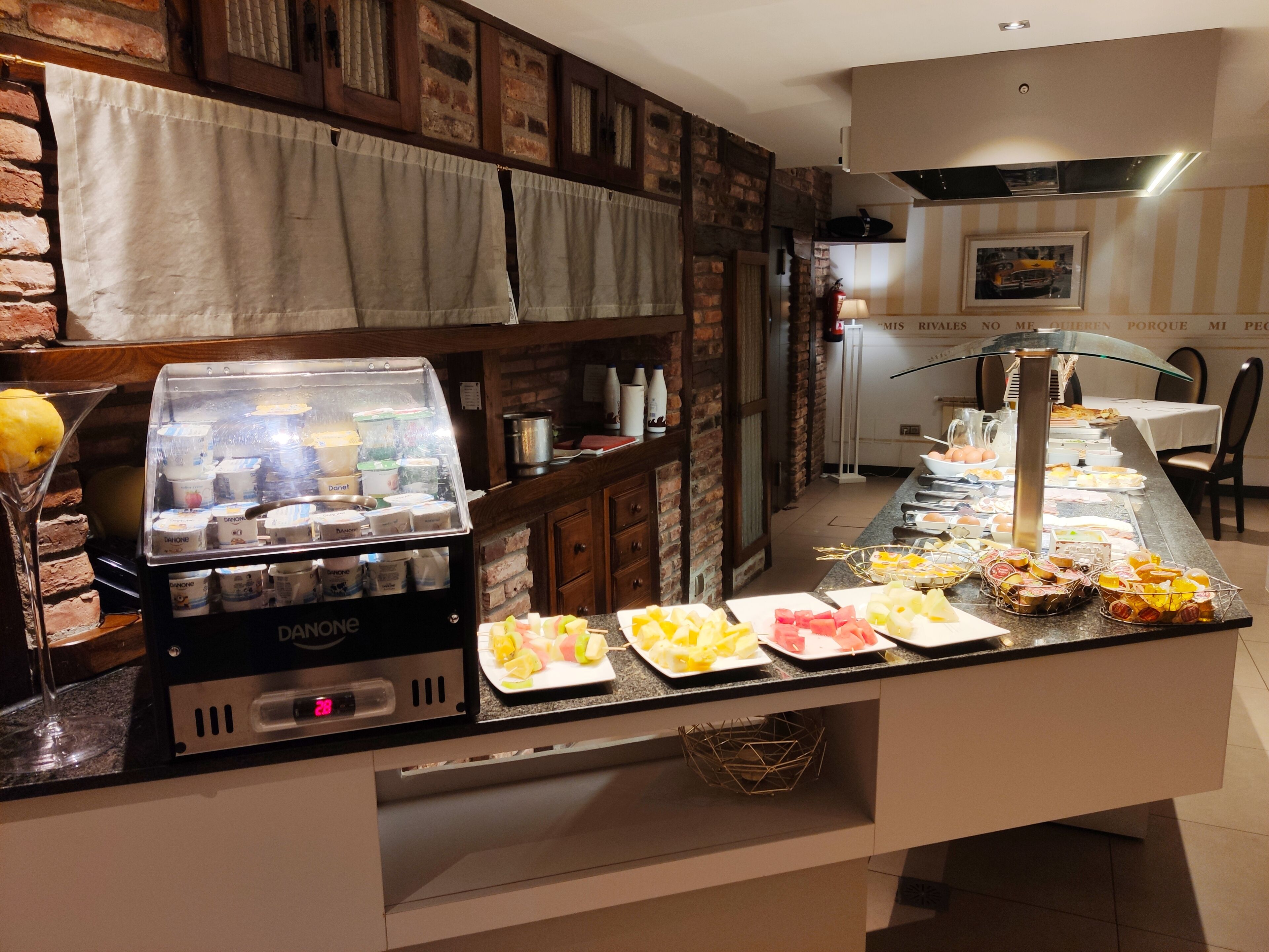 A buffet setup with various food items and a refrigerator filled with beverages.