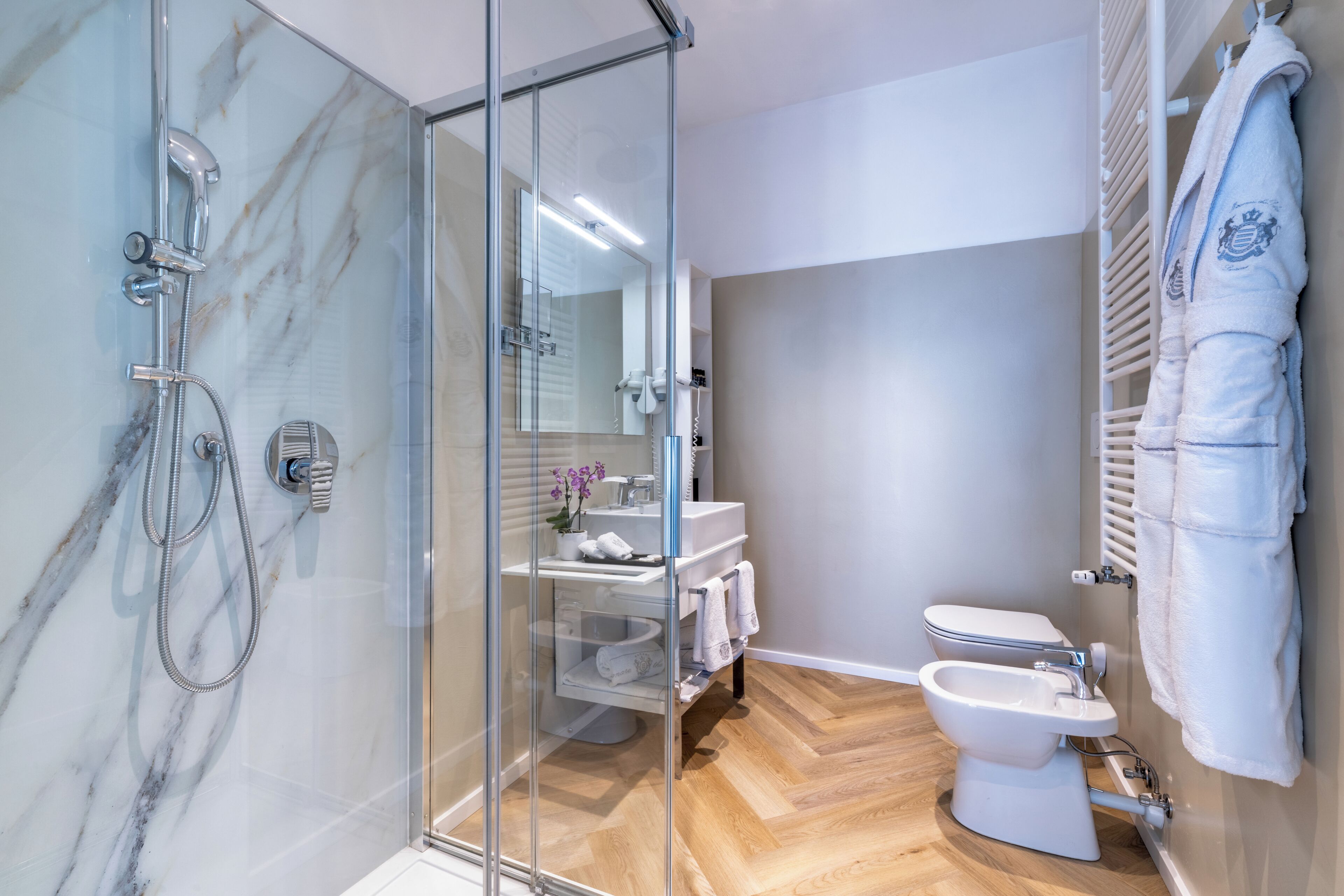 Un baño moderno con ducha envuelta en cristal, inodoro y bidé.