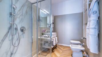 Un baño moderno con ducha envuelta en cristal, inodoro y bidé.