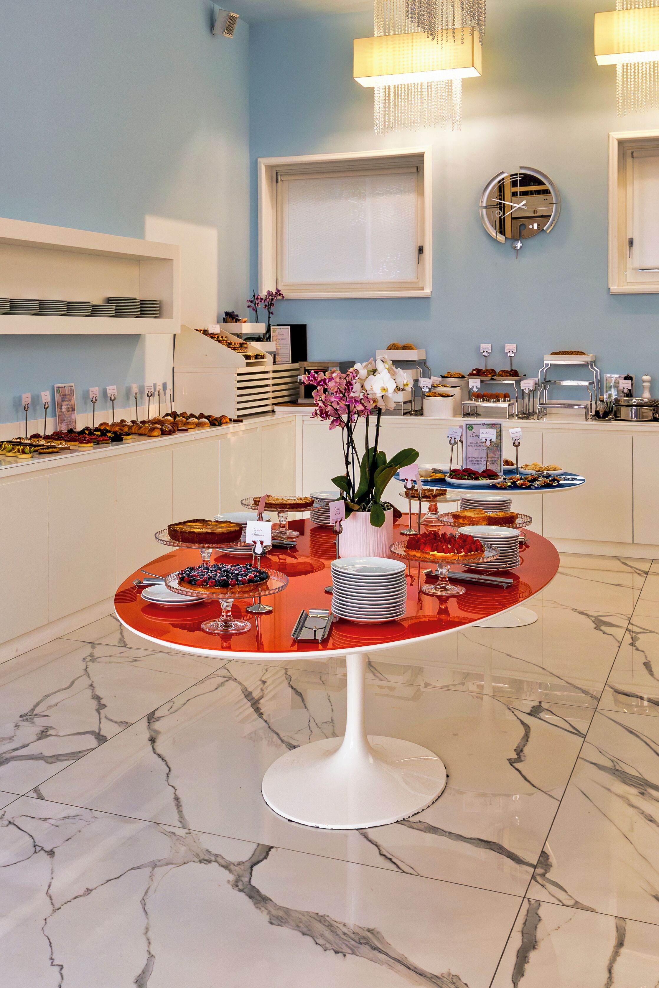 A buffet setup with various food items and a clock on the wall.