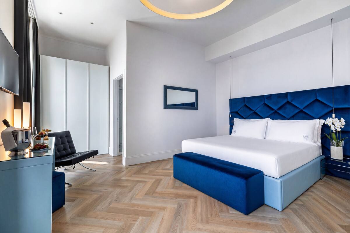 Une chambre moderne avec un grand lit, un bureau avec une chaise et un téléviseur.