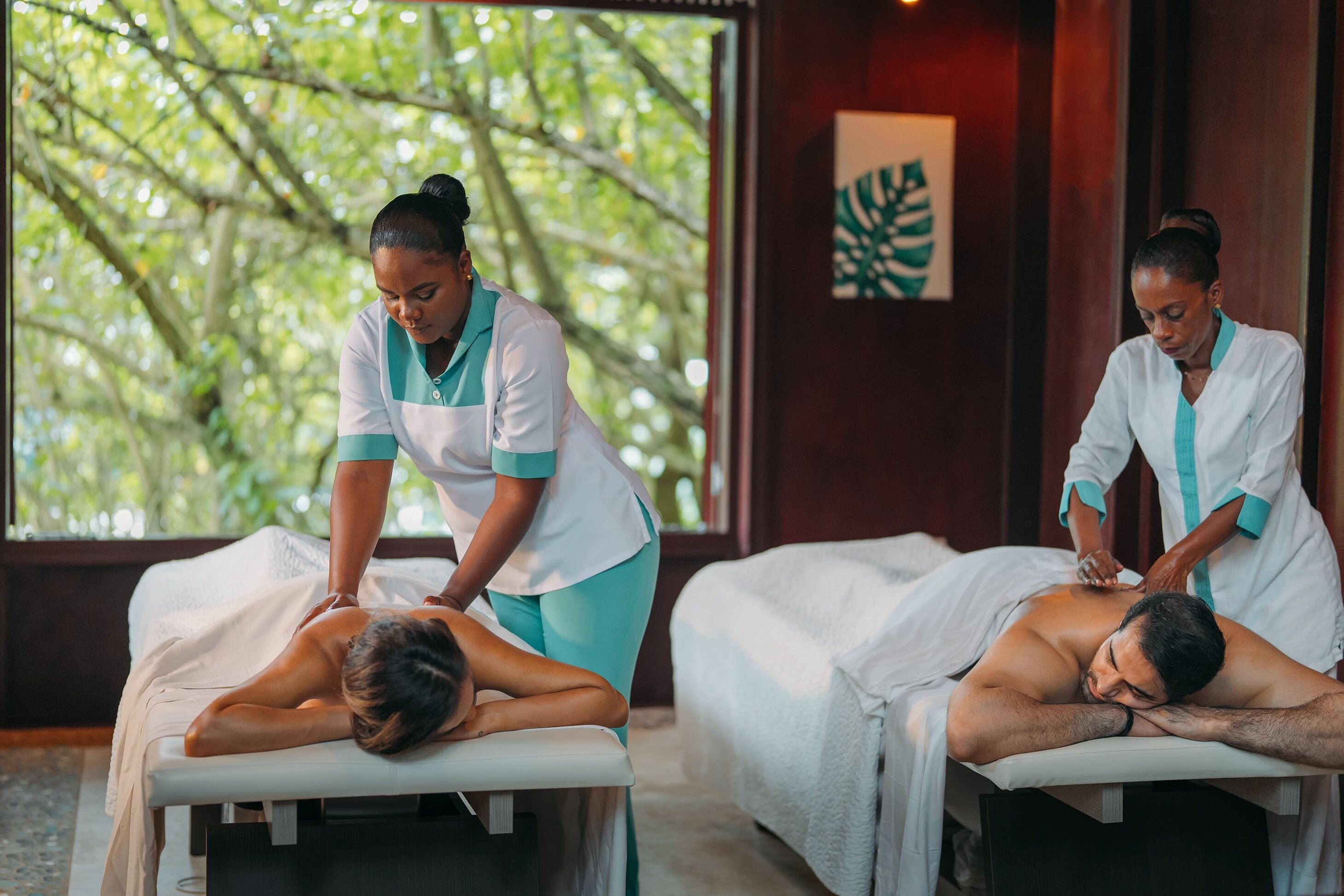A massage therapy room with two clients receiving treatments.