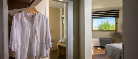 A bedroom with a bed, a bedside table, and a window with a view.