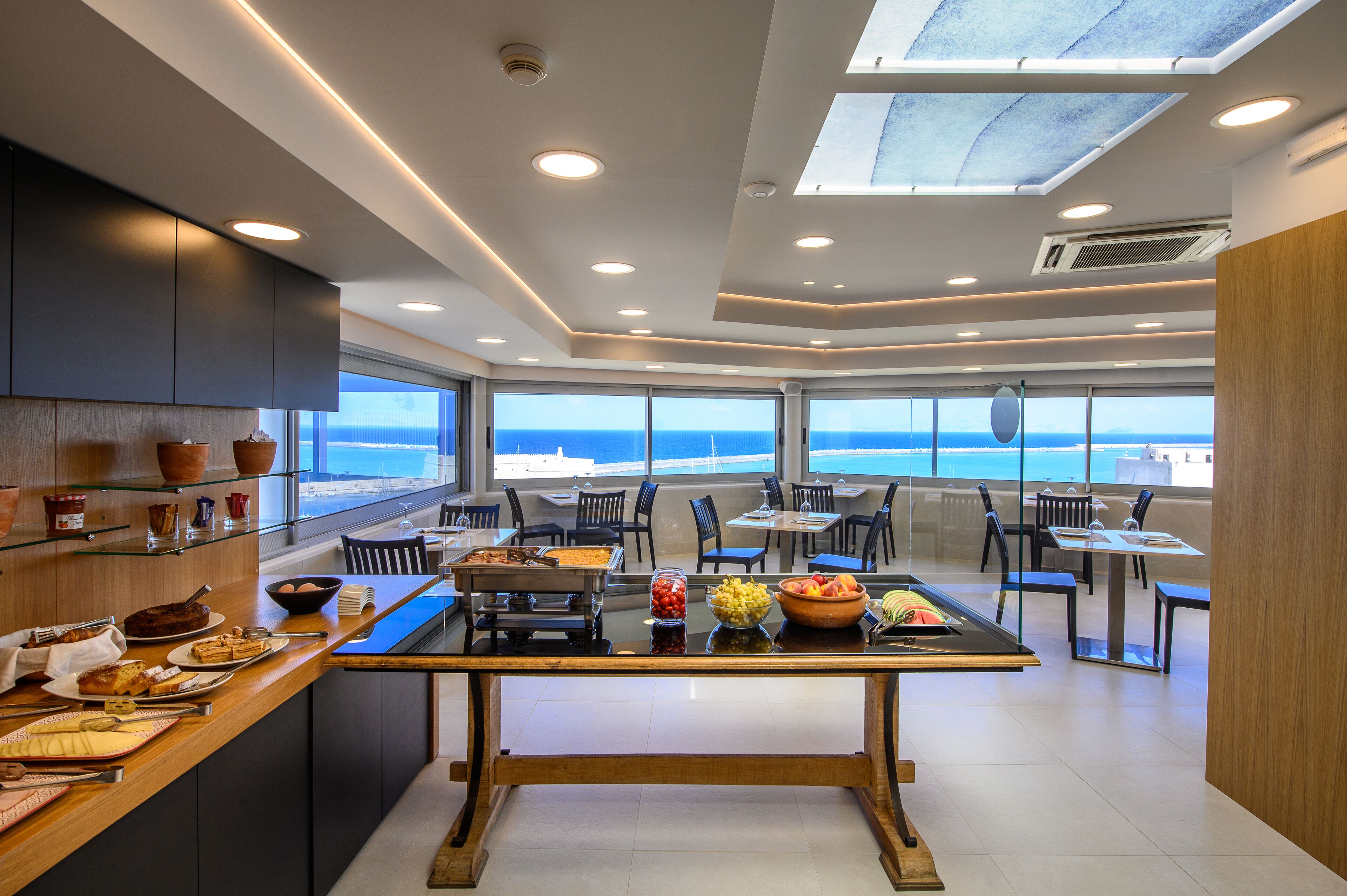 Uma sala de jantar moderna com uma mesa comprida, cadeiras e um sistema de buffet.
