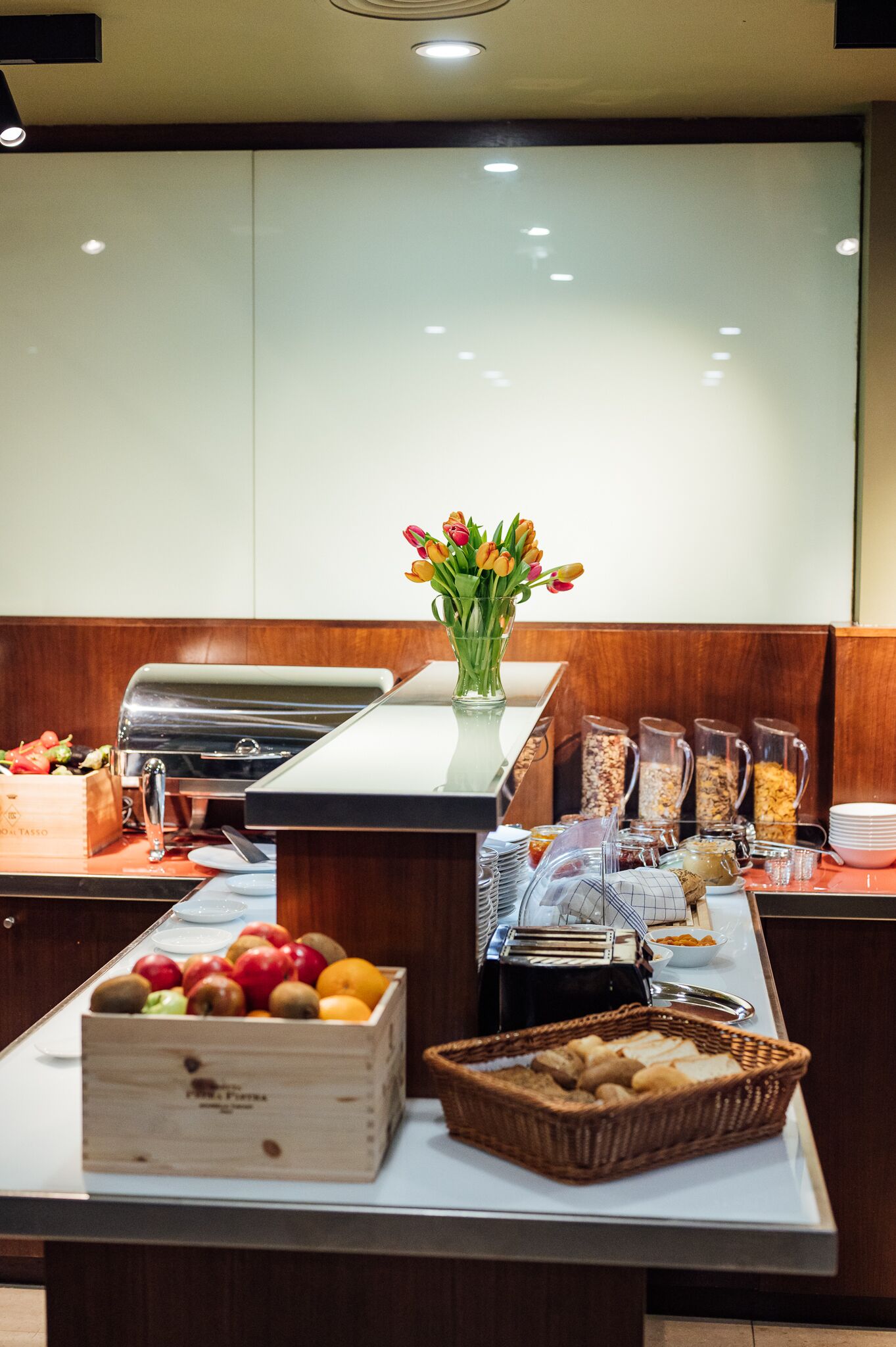Een buffetopstelling met diverse gerechten en een bloevas.