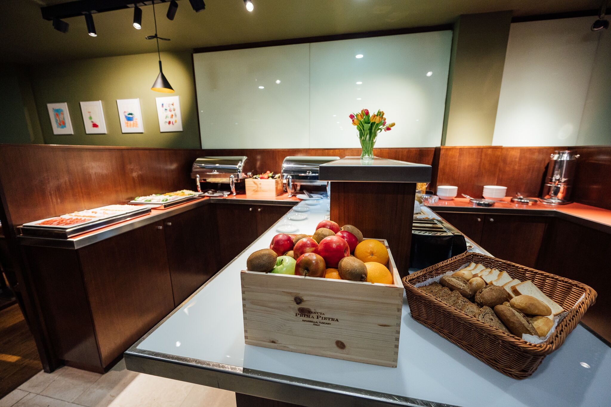 A buffet area with a variety of fruits and bread.